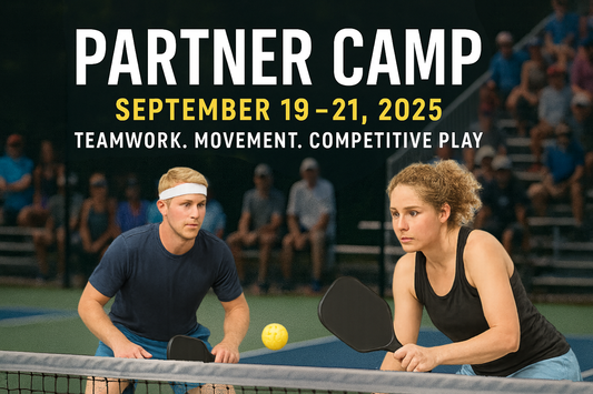 Two focused pickleball players, a man and a woman, prepare to return a shot at the net on an outdoor court during a competitive game. The scene is set against blurred stadium bleachers filled with spectators. Bold text at the top reads “Partner Camp” with the dates “September 19–21, 2025” and the tagline “Teamwork. Movement. Competitive Play.”